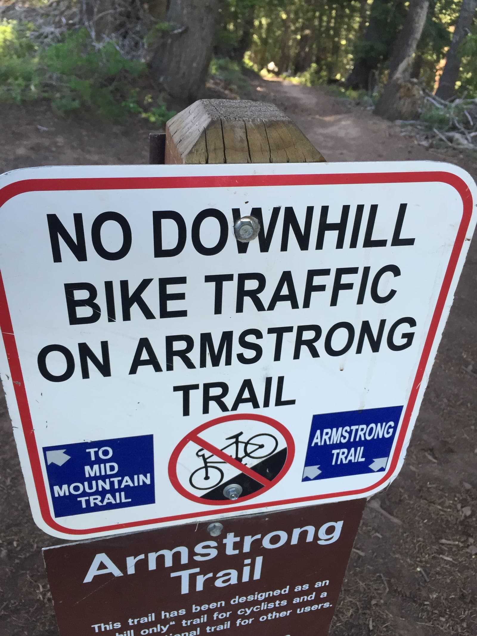 Trail sign: no downhill bike traffic on Armstrong Trail, with arrows to Mid Mountain Trail